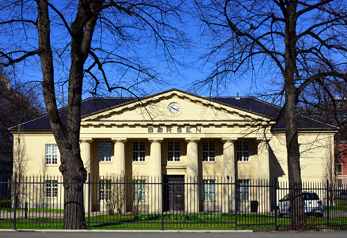 Oslo, Norway: neo-classical façade of the Oslo Stock Exchange (Oslo Børs ASA, OSE ). Founded in 1819 in what was then Christiania. Norway's only regulated marketplace for trading shares, equity certificates and other securities , such as derivatives and bonds. The Euronext consortium of European stock exchanges controls Oslo Stock Exchange since 2019 - The OBX Index is the most important stock index on the Oslo Stock Exchange. The stock exchange building is located on the leafy Tollbugata, it was completed in 1829  according to drawings by architect Christian Heinrich Grosch.