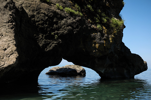 Picturesque view of natural stone arch above sea. Rock formation