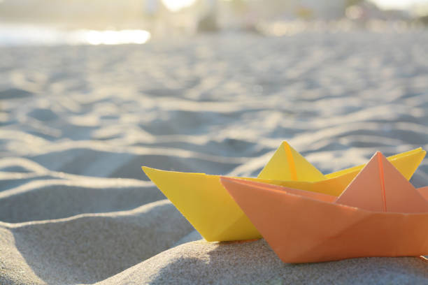 istock Colorful paper boats on sand outdoors, space for text 1736046058