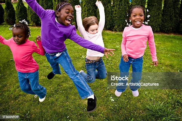 Четыре Счастливые Девушки Прыжки На Улице — стоковые фотографии и другие картинки 4-5 лет - 4-5 лет, 6-7 лет, 8-9 лет