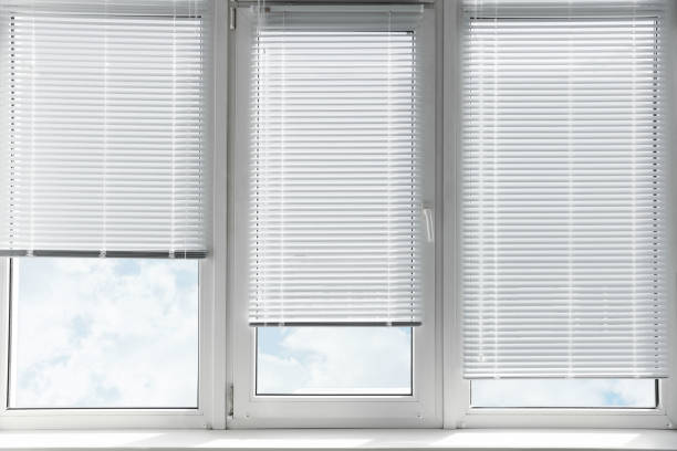 istock Stylish window with horizontal blinds in room 1736056586