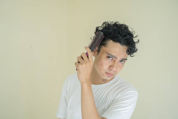 istock Young curly man wear white t-shirts when combing hair. 1736060964