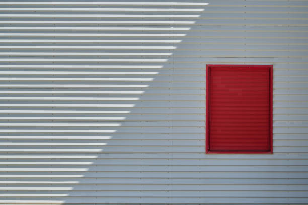 shade and sunlight on urban factory wall with window