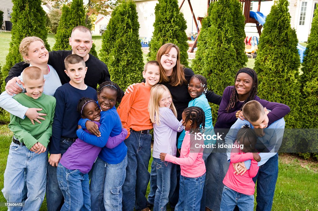 Adoptive Family A father and mother with two biological children and ten adopted children. Child Stock Photo