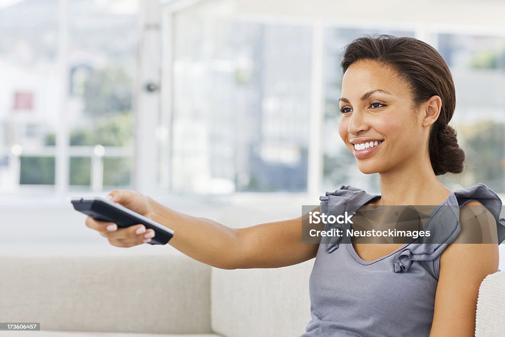 Sorrindo Jovem mulher com controle remoto - Foto de stock de Controle Remoto royalty-free