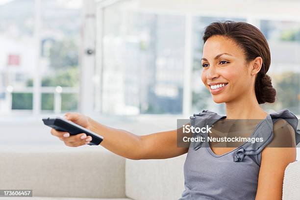 Foto de Sorrindo Jovem Mulher Com Controle Remoto e mais fotos de stock de Controle Remoto - Controle Remoto, Pessoas, 20 Anos