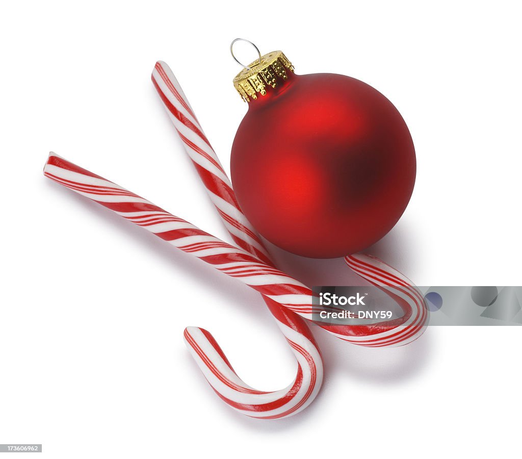 Christmas Ornament & Candy Cane Two candy canes with red Christmas ornament on white background. Soft shadow.To see more holiday images click on the link below: Candy Stock Photo