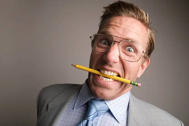 "Stressed out businessman looks ready to blow his fuse, or at least bite through the pencil in his mouth"