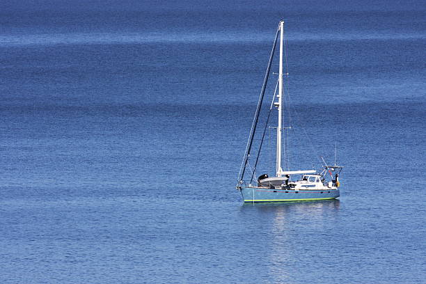 Lone sailboat at anchor on calm azure sea.  California Coast, 2008.