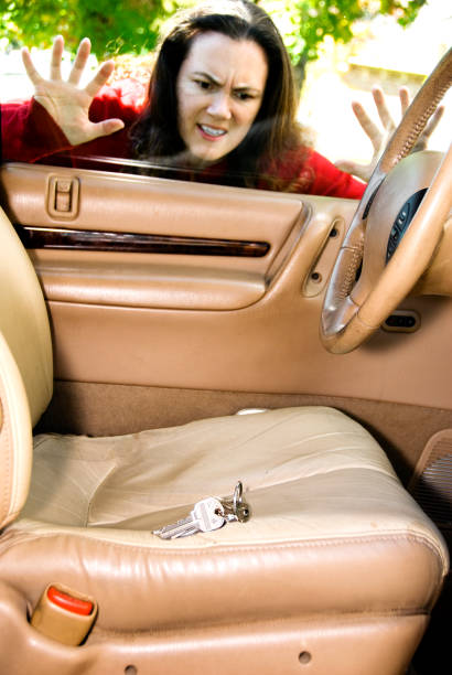 Frustrated woman looking inside locked car with keys on seat A woman has locked her keys in her car. lock photos stock pictures, royalty-free photos & images