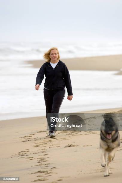 Gehen Sie Mit Dem Hund Am Strand Stockfoto und mehr Bilder von 55-59 Jahre - 55-59 Jahre, Aerobic, Deutscher Schäferhund