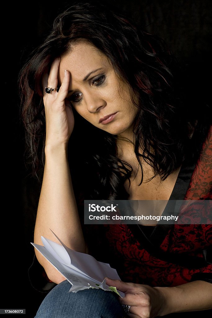 Mujer triste lee carta - Foto de stock de 20 a 29 años libre de derechos
