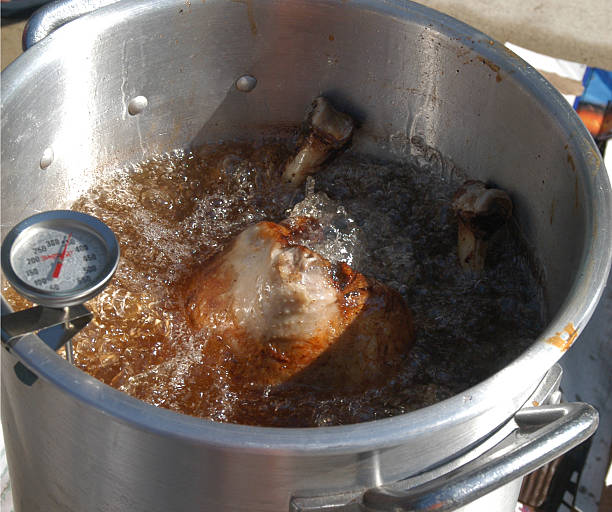 Turkey Frying A full-size turkey being fried in peanut oil. deep fried photos stock pictures, royalty-free photos & images