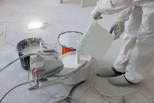 istock Decorator pouring paint in bucket on white floor, closeup 1736089216