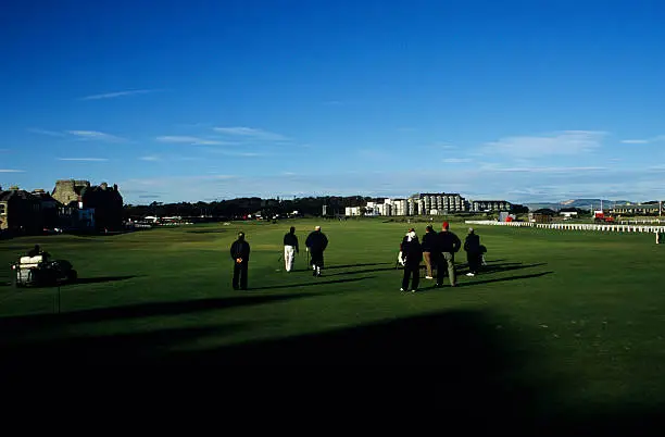 A group of men playing the St.Andrews golf course in Scotland.