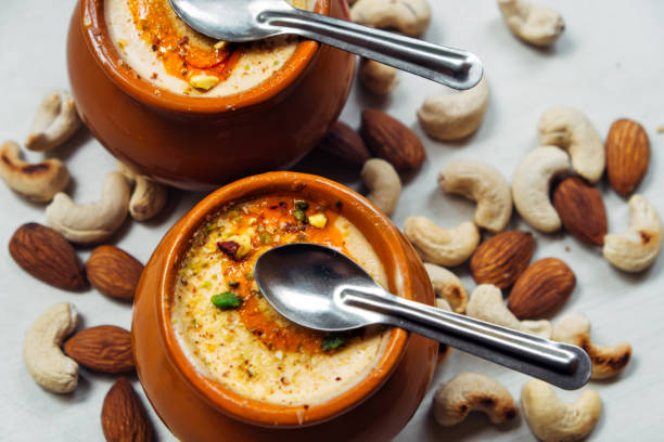 istock Kulfi ice cream in two clay pots with small dessert spoon on a white background. 1736097864