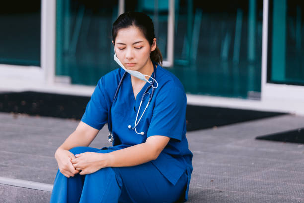 istock Stressed nurse sitting in hospital corridor 1736101726