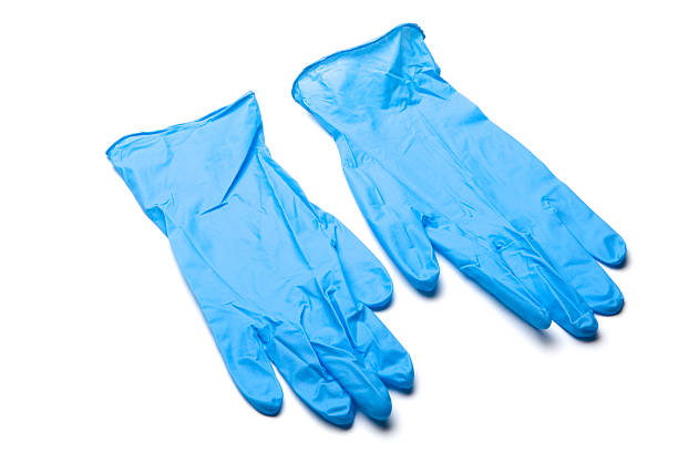 Pair of blue surgical gloves laying on white background Pair of blue, wrinkled surgical gloves on white background. No selection made. surgical glove stock pictures, royalty-free photos & images