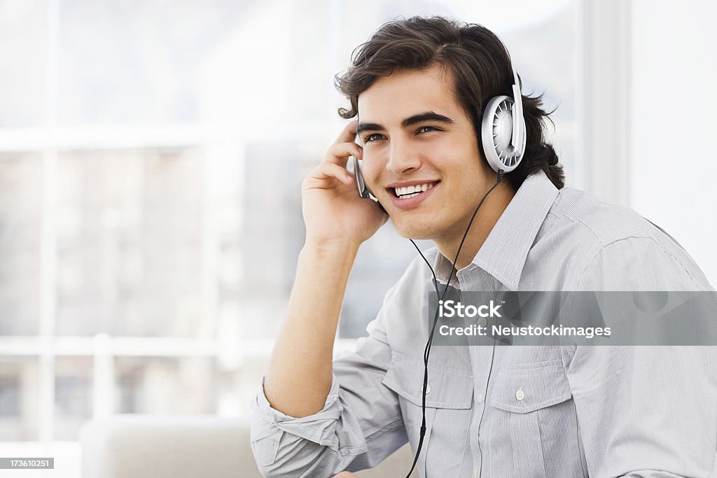 音楽を聴いて笑う若い男性 - 20-24歳のロイヤリティフリーストックフォト