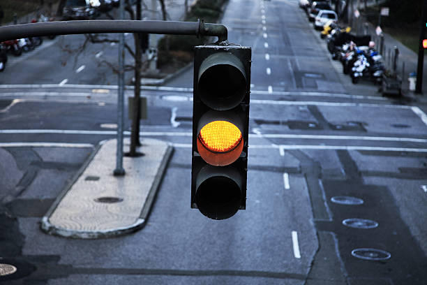 Close-up of hanging traffic light with yellow light on stock photo