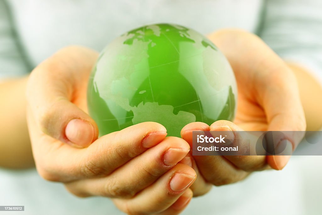 Green globe being held by a person's hands Green globe in hands Globe - Navigational Equipment Stock Photo