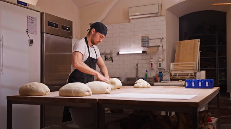 Caucasian Baker Kneading Dough In A Small Bakery