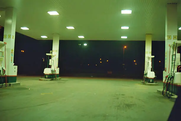 Close up of a petrol station lit up at night.