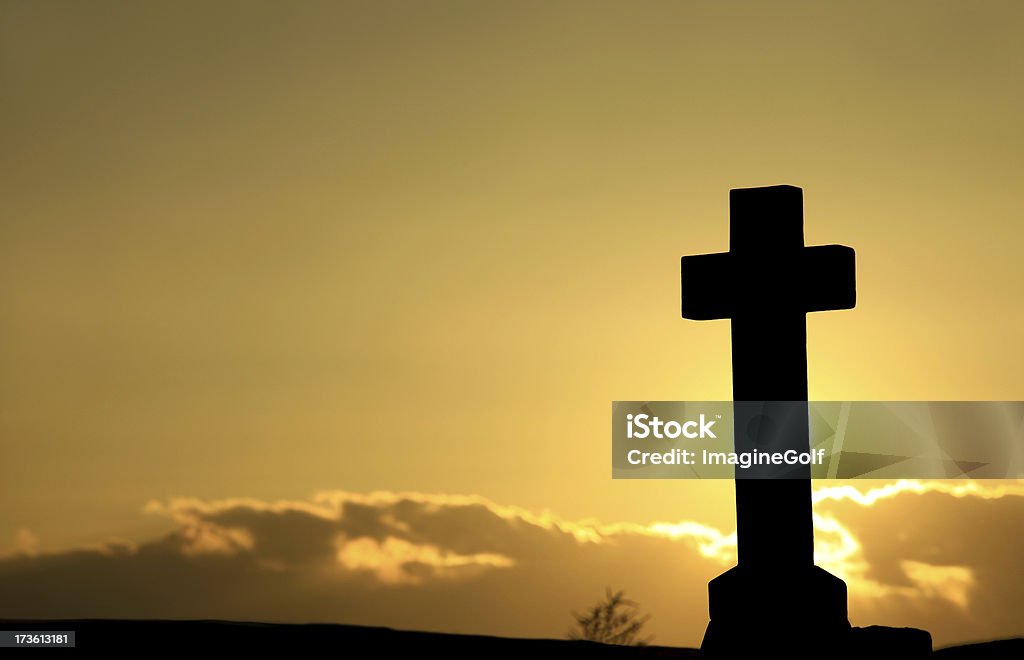 Silhueta de uma cruz em frente de um pôr do sol nublado - Foto de stock de Amarelo royalty-free