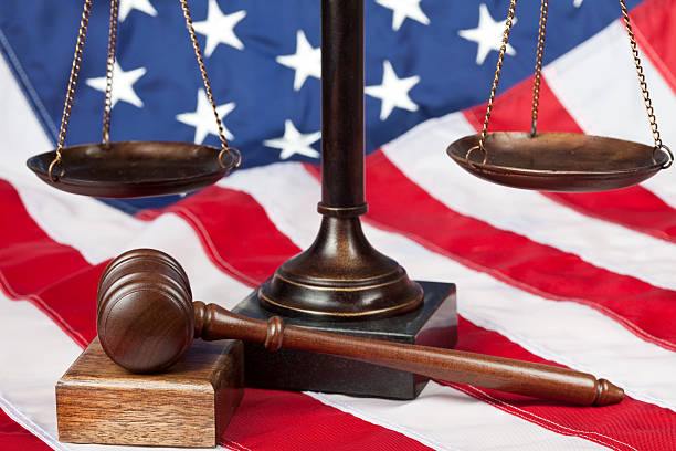 Scale and gavel on US flag Scale of justice and gavel on American flag. Selective focus. equal arm balance photos stock pictures, royalty-free photos & images