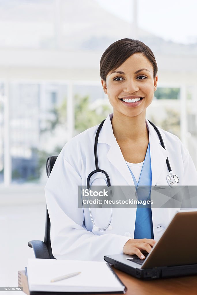 Smiling female doctor using laptop Closeup of a smiling female doctor using laptop Doctor Stock Photo