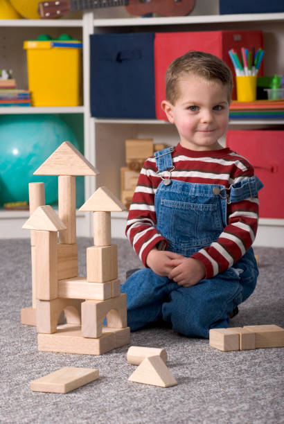 istock Young Boy Building With Wooden Toy Blocks Vertical Looking Smug 173615390
