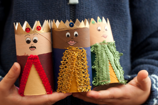 A child is holding home-made three kings in his hands.Epiphany - (1/6) Also known as Three Kings' Day celebrates the visit of the 3 wise men.
