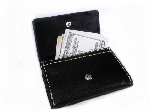 A balck wallet with money coming out of it.