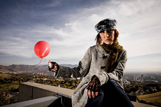 istock Woman Sitting on Rooftop Holding Balloon 173616164