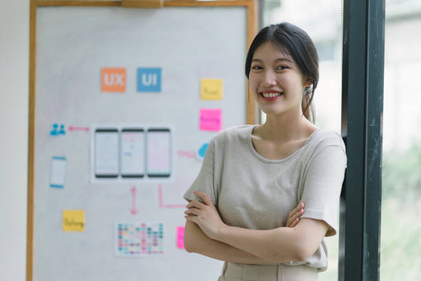 istock Portrait of creative UX UI designer working on screens for mobile responsive website development, focusing on UI UX. Developing wireframe sketch layout designs on a smartphone screen. 1736162119