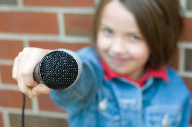 This little girl is working on being a reporter when she grows up by interviewing people with her microphone.