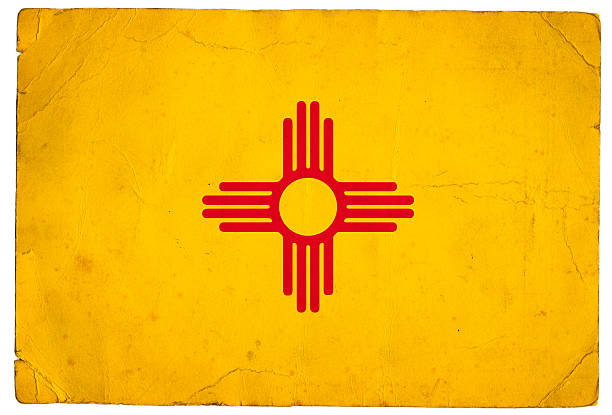 The flag of the US state of New Mexico on an old piece of paper.  A red sun symbol of the Zia on a field of yellow. The colors honor Isabella of Castile and the conquistadors who explored in her name.This series: