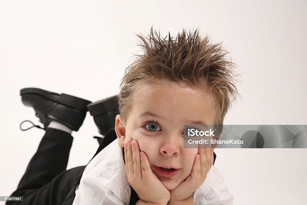 Niño atractivo orificio de sujeción de cabeza con las manos en la cara - Foto de stock de Cabello de punta libre de derechos