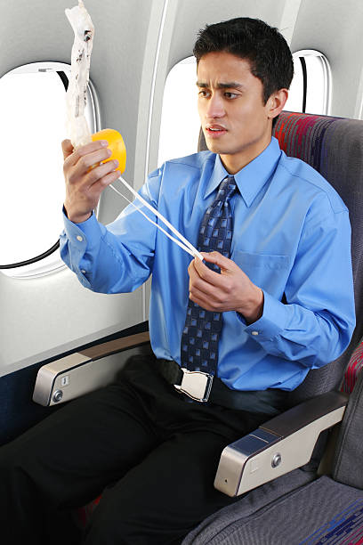 Passenger on a commercial airliner putting on an oxygen mask.