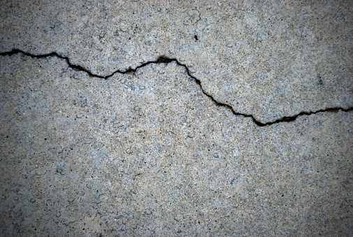 A grunge texture of sidewalk and a crack running through it