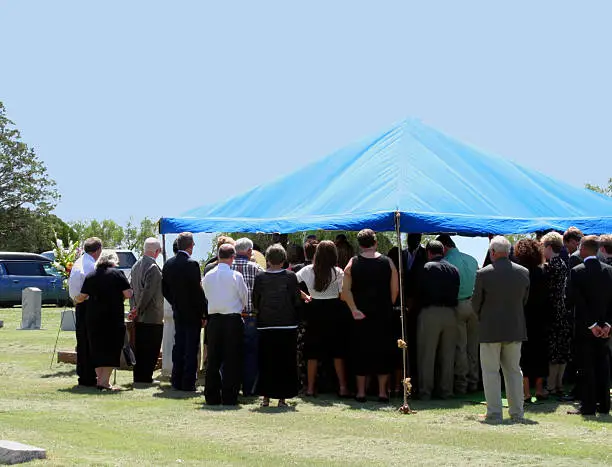 Friends & relatives at the interment of a loved one at the cemetery.