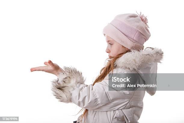 Kleines Mädchen Im Weißen Mantel Zeigen Etwas Auf Die Handflächen Stockfoto und mehr Bilder von Kälte