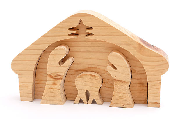 Wooden nativity scene figures with trees and manger displayed on a shelf