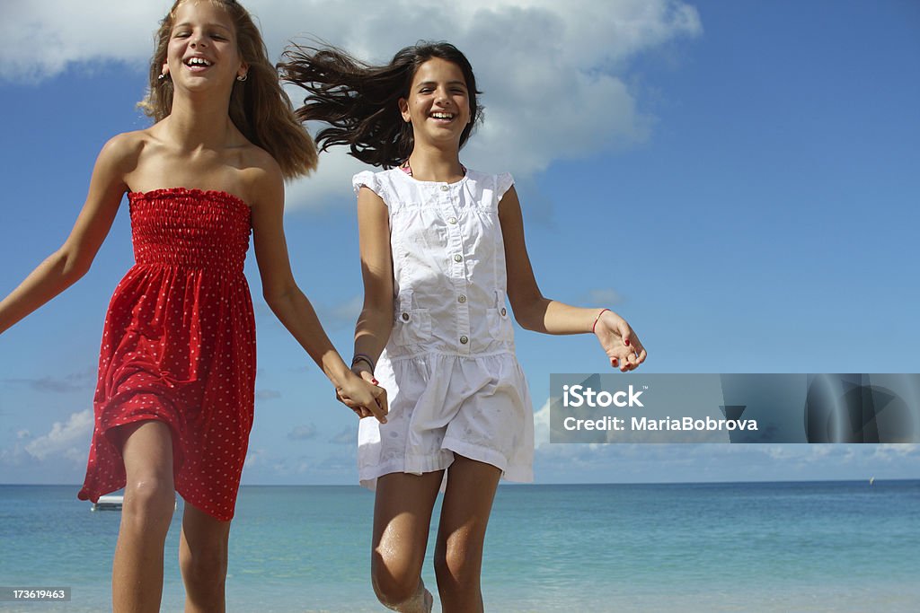 two sisters Two sisters (10 and 12) running on the beach. Caribbeans. 10-11 Years Stock Photo