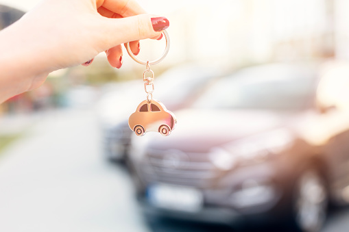 Female car salesperson handing over the new car keys