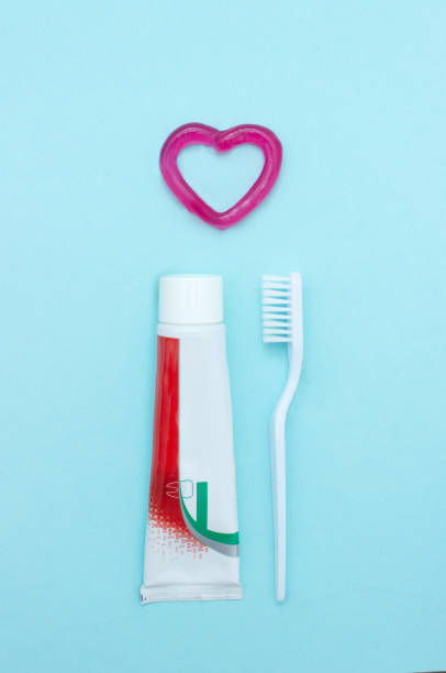 istock Closeup of a toothpaste, toothbrush and toothpaste heart on blurred blue background. Means to care for the oral cavity. 1736204543