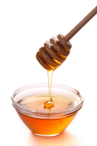 Honey with dripper on white