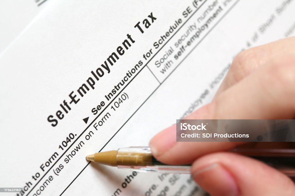 Self Employment Tax Form Filling out a Self Employment Tax Form.See more tax related photos: Self-Employment Stock Photo