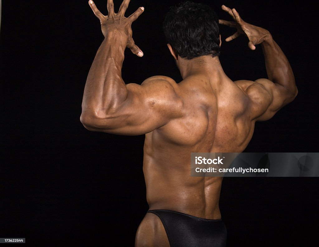 I muscoli posteriori flette bodybuilder a maschio - Foto stock royalty-free di Abbronzatura