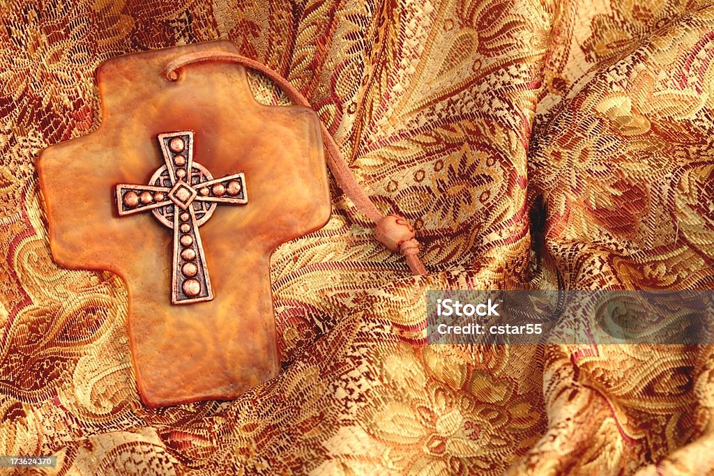 Cross on Brocade Small copper cross on amber colored glass laying on beautiful brocade fabric. label showing no copyright uploaded in MRClick to view more Christian Easter images Amber Stock Photo